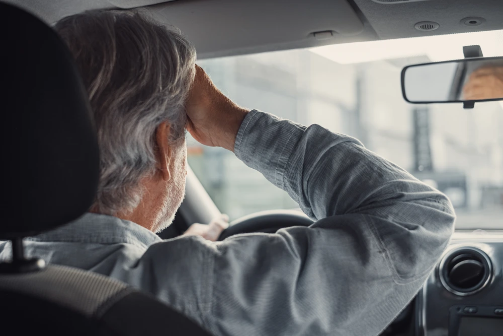 Stressed oldman feeling headache in car,